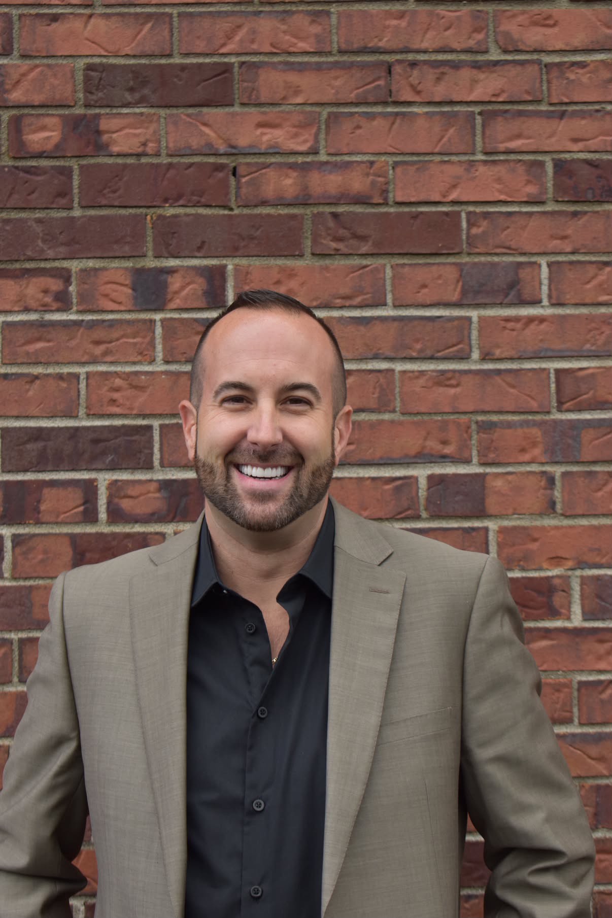 Christopher Rae smiling in a light suit